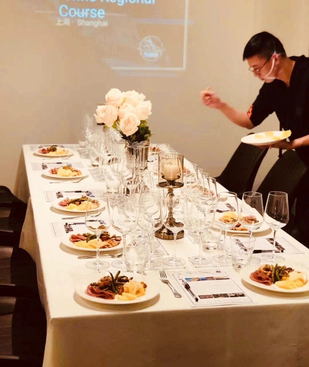 Details of prepared dishes, wine glasses and flowers at a private dinner