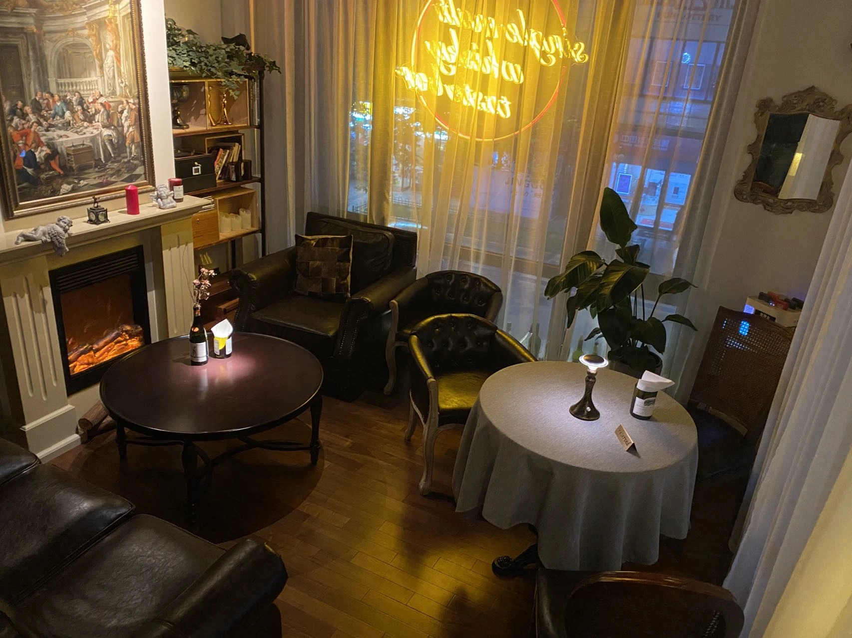 Armchairs and tables by the fireplace at Pure Wine