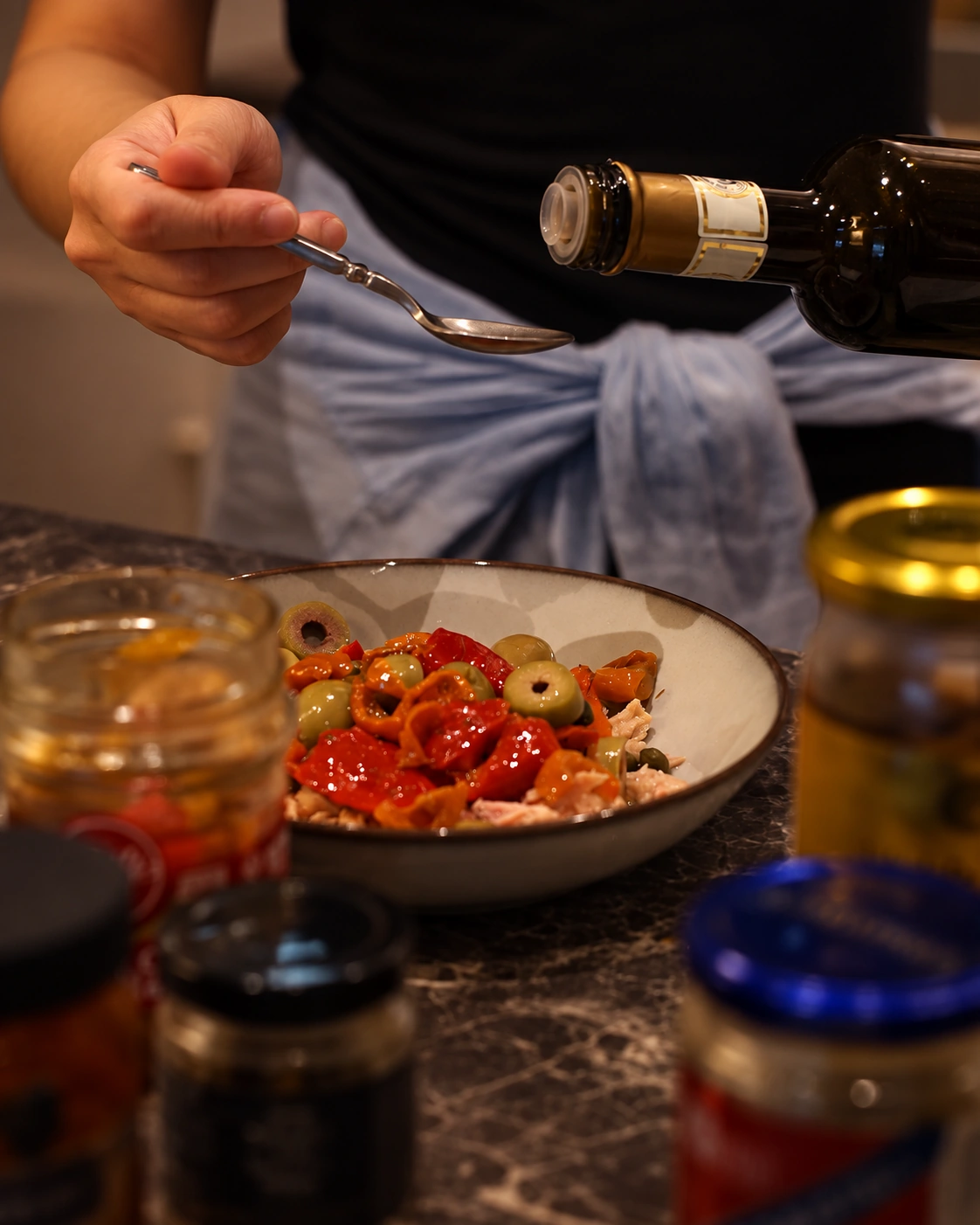 Wine being poured into a spoon beside a freshly prepared dish