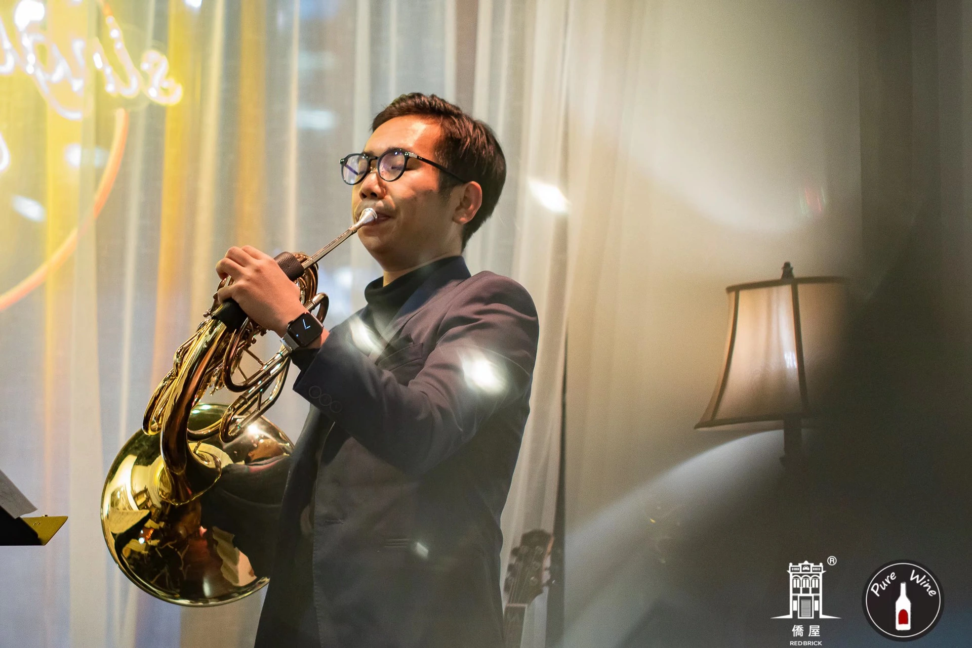 A musician performing on a brass instrument at Pure Wine